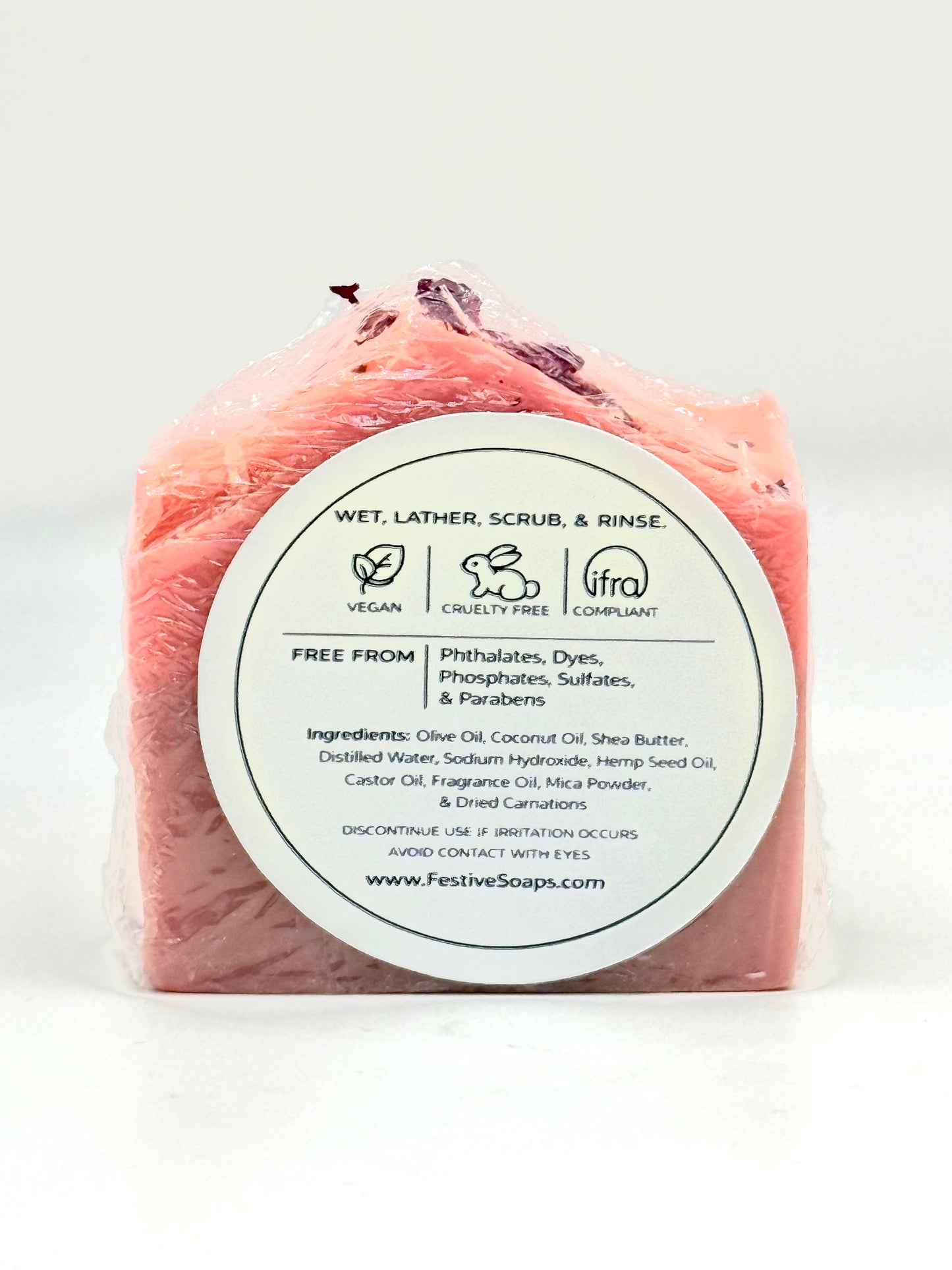 Pink soap bar with a white label on a white background