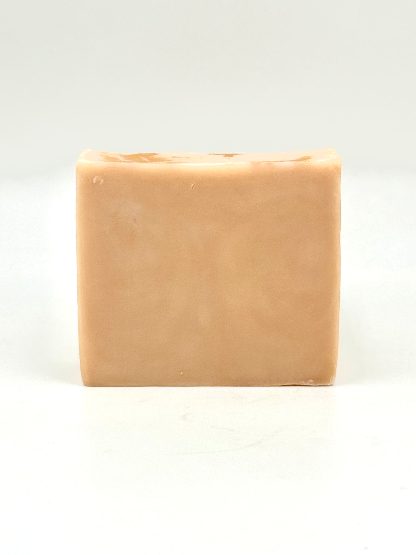 naked bar of beige soap on a white background 