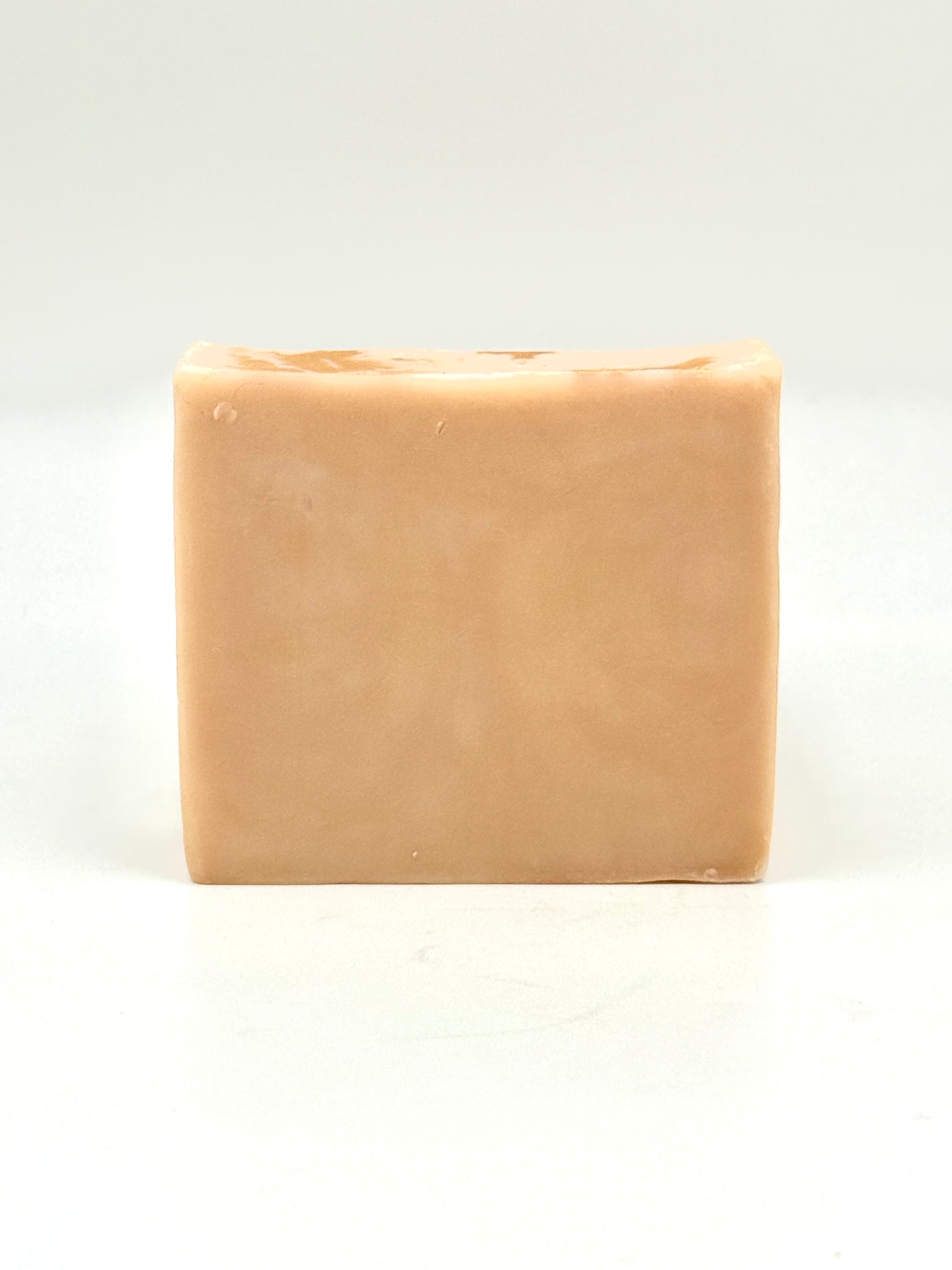 naked bar of beige soap on a white background 
