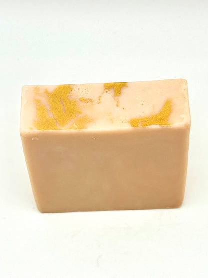 Rectangular bar of soap with gold marbling on top on a white background