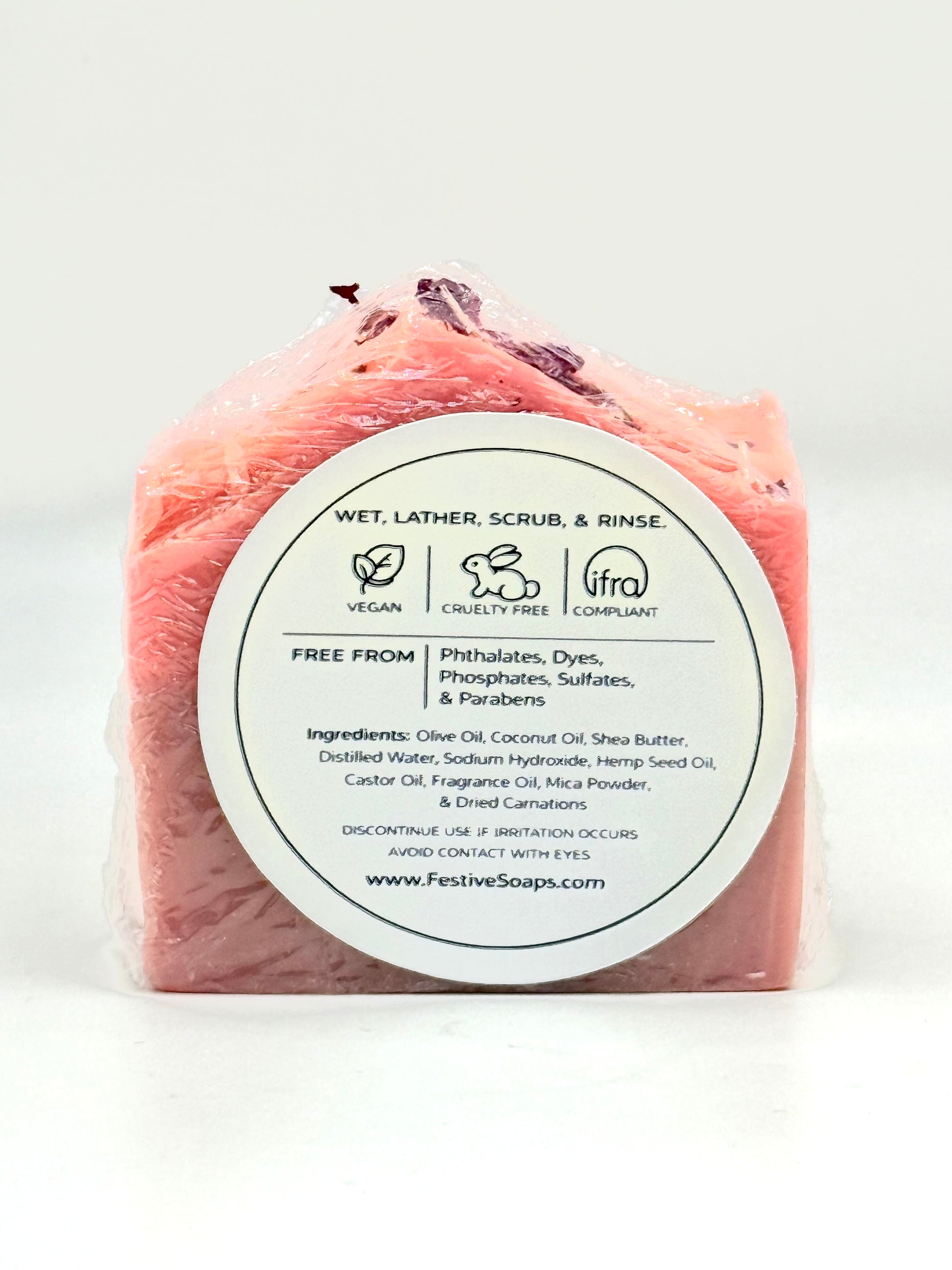 Pink soap bar with a white label on a white background