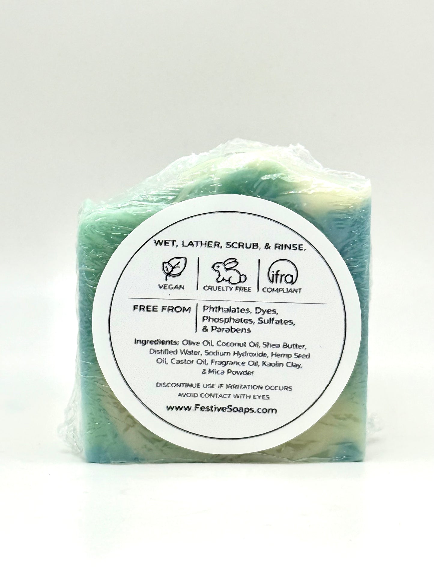 Green bar of soap with a white label on a light gray background