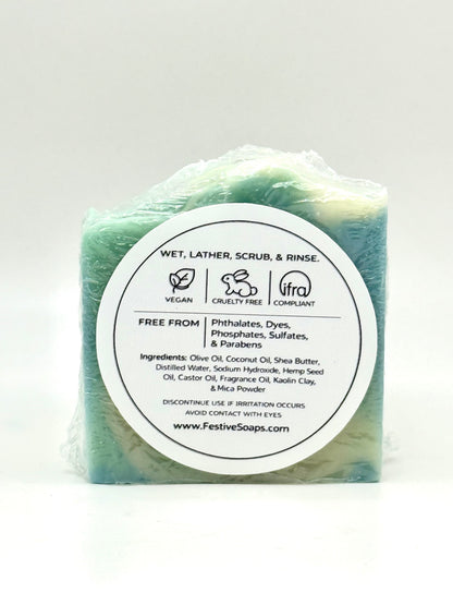 Green bar of soap with a white label on a light gray background
