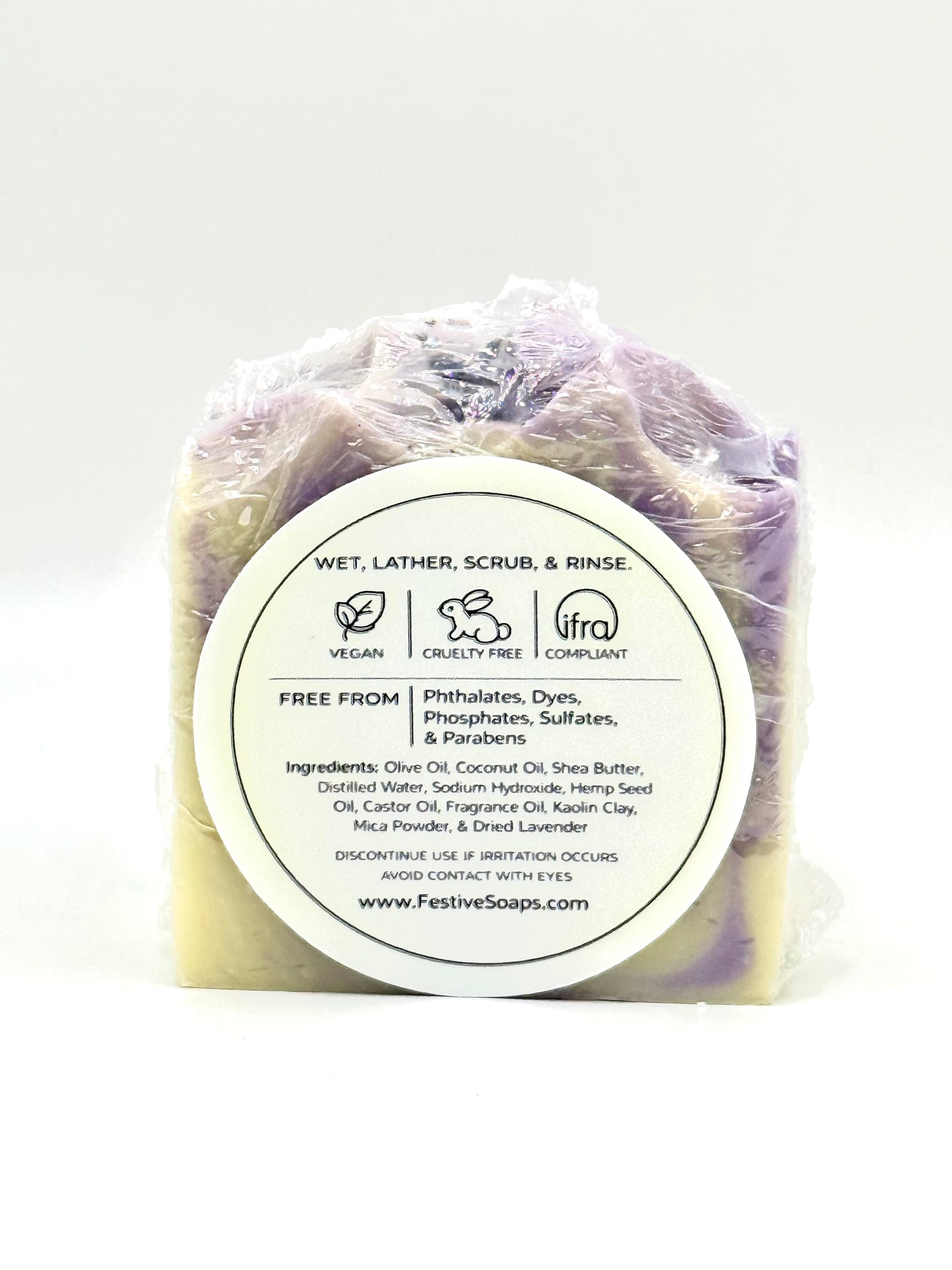 Bar of soap in clear plastic wrap with a label on a white background
